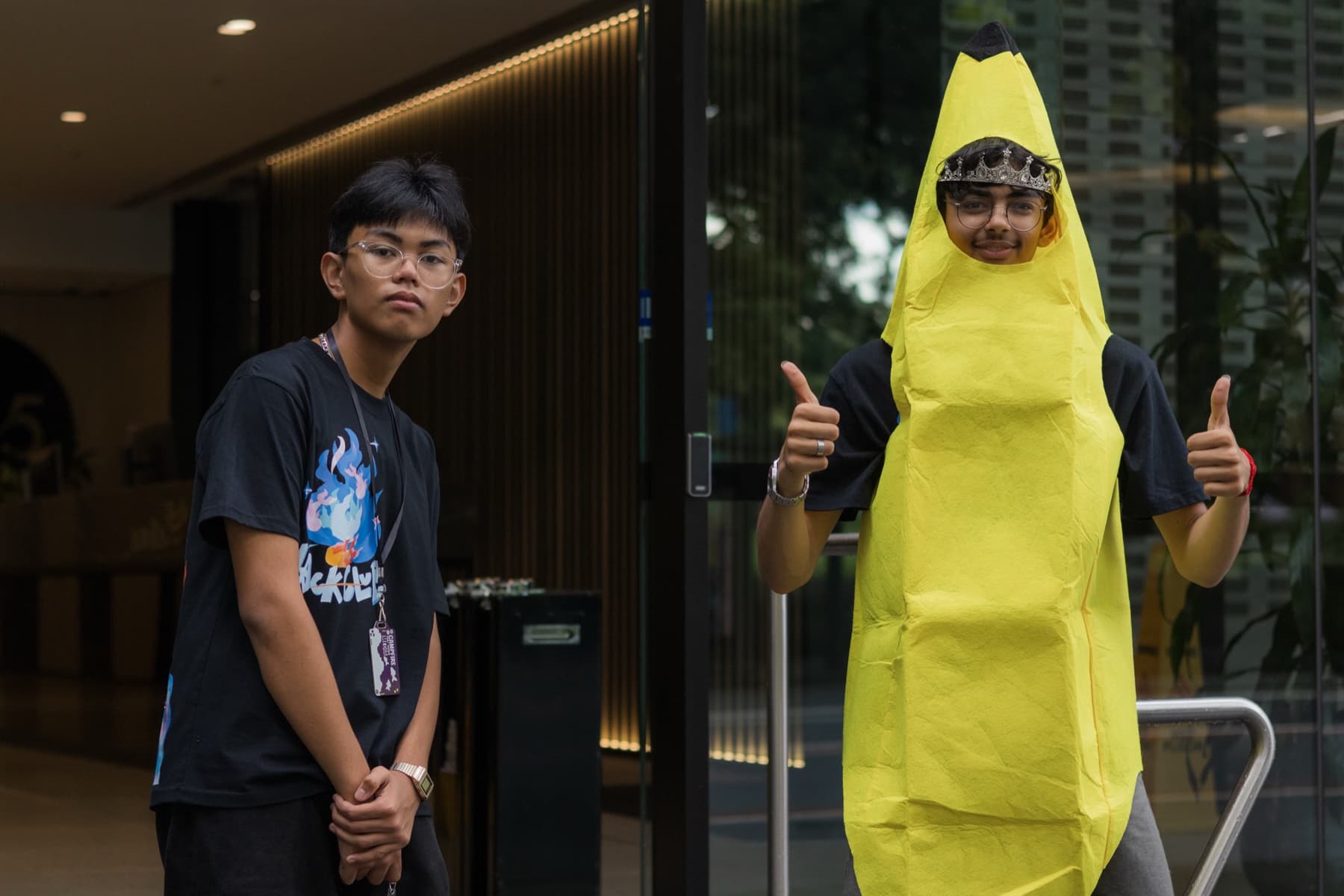 Two teenagers standing outside a venue, one wearing a banana costume